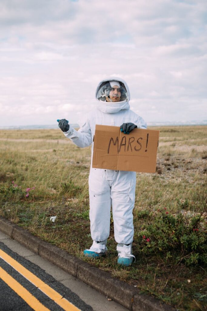 A person in a spacesuit hitchhiking with a Mars sign, on a deserted road.